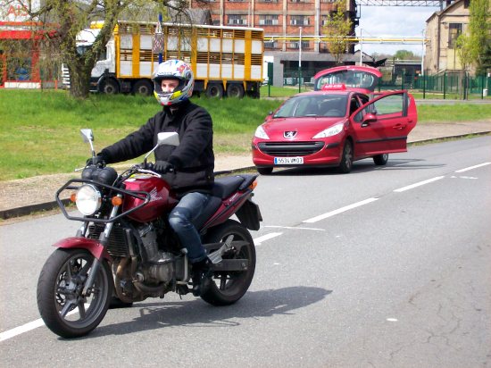 Élève en formation deux-roues aux côtés d'une voiture école